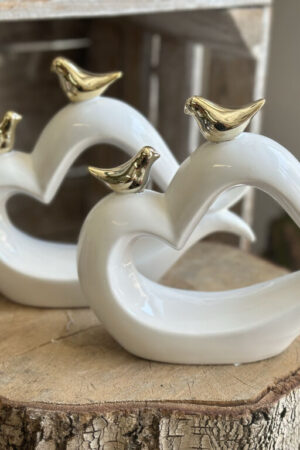 Białe ceramiczne serce ze złotymi wróbelkami.