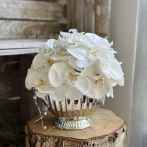 Kompozycja wykonana w ceramicznym srebrnym naczyniu z dodatkiem silikonowych kwiatów storczyka, idealna kompozycja do postawienia na stole.