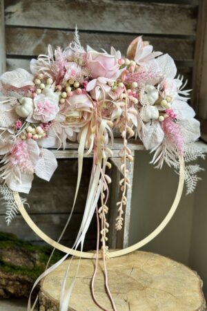 Obręcz drewniana wykonana w stylu boho dodatkiem różowych i kremowych kwiatów, gałązek, liści oraz białych dyń.