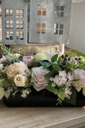 Kompozycja do postawienia na stole, wykonana w czarnej ceramicznej podstawie. Wykonana z kwiatów pastelowych róż, hortensji, ostróżki, ostów.