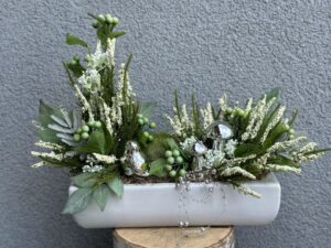 Kompozycja jesienna wykonana z ceramicznymi srebrnymi grzybkami i ptaszkiem. Całość wykonana w białym naczyniu z dodatkiem jesiennych roślin.