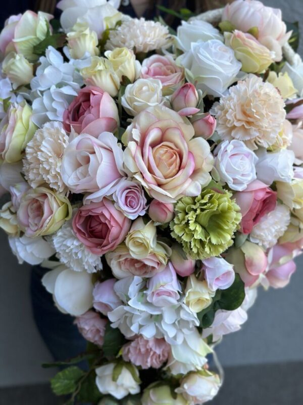 Kompozycja nagrobna wykonana w kształcie serca z pastelowych kwiatów i ze wkładem do wazonu w komplecie.