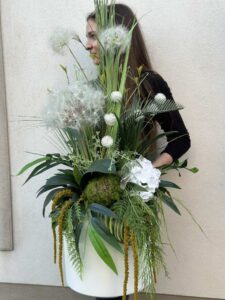 Kompozycja z dmuchawcami i kwiatem hortensji w białej plastikowej osłonce