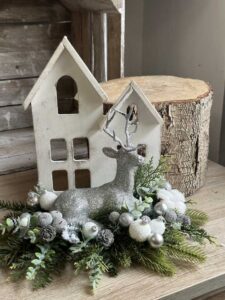 Dekoracja świąteczna ze srebrnym reniferem i białym drewnianym domkiem