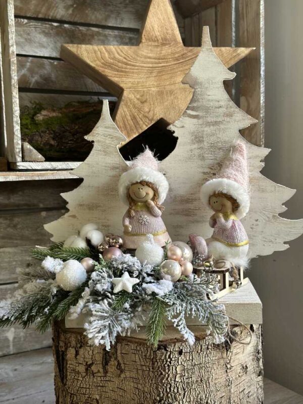 Kompozycja świąteczna z różowymi dziećmi na drewnianej białej podstawie.