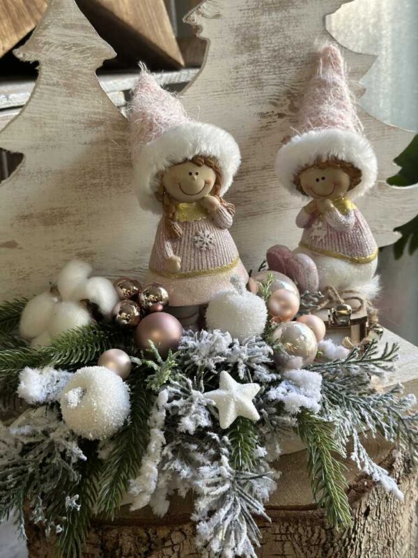 Kompozycja świąteczna z różowymi dziećmi na drewnianej białej podstawie.